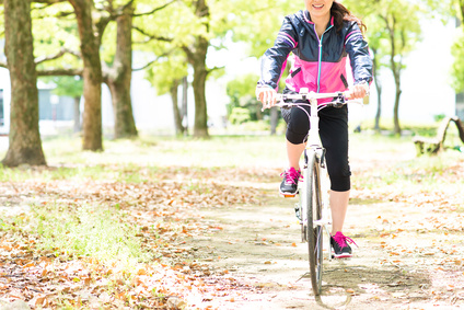 自転車に乗って森の中をサイクリングする日本人女性